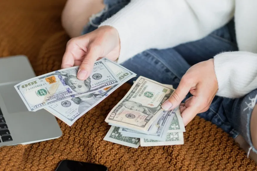 Pila abundante y ordenada de billetes de 100 dólares estadounidenses mostrando el rostro de Benjamin Franklin, representando visualmente los beneficios del minimalismo financiero digital: la acumulación de capital clara y sin distracciones al eliminar herramientas innecesarias.