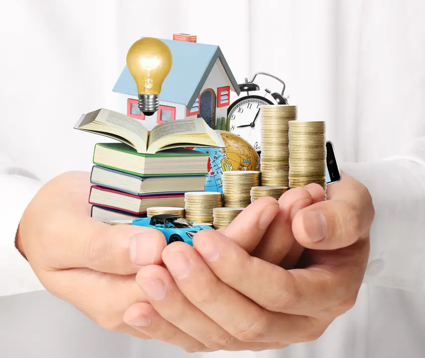 Manos sosteniendo monedas, una casa, libros y un reloj, representando la capa financiera de un ecosistema SaaS