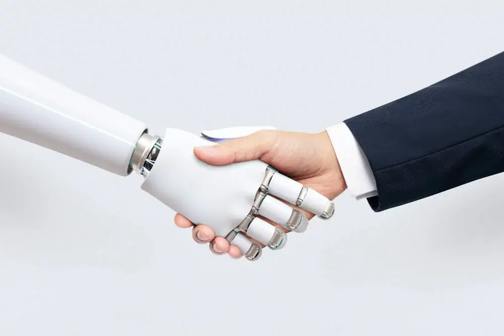 Apretón de manos entre un robot y una persona, representando la colaboración entre inteligencia artificial y criterio humano en las finanzas