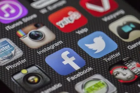Pantalla de smartphone saturada con múltiples iconos de aplicaciones de redes sociales y servicios, ilustrando visualmente el exceso de herramientas digitales que complican la gestión diaria y la toma de decisiones financieras en lugar de simplificarla.
