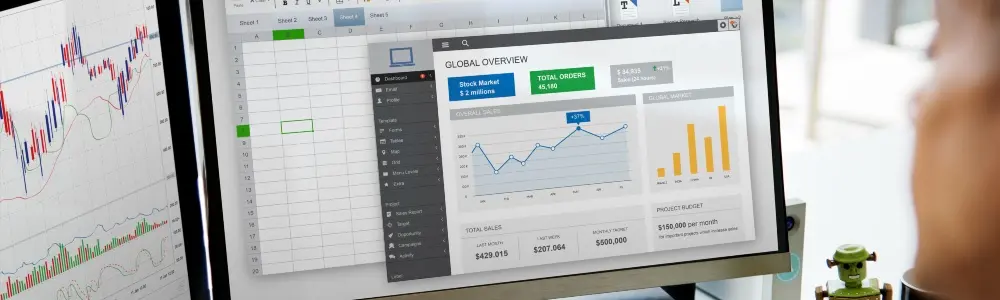 Monitor mostrando un dashboard financiero con gráficos de ventas, órdenes y presupuesto en tiempo real